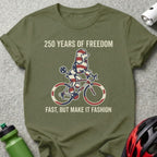 Olive green t-shirt with poodle riding a bicycle, "250 YEARS OF FREEDOM, FAST, BUT MAKE IT FASHION."