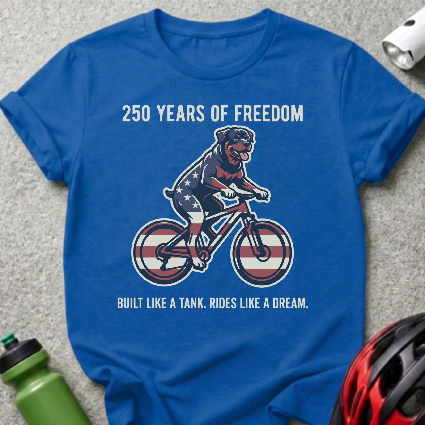 Rottweiler on a bicycle with American flag details, text "250 Years of Freedom" and "Built Like A Tank. Rides Like A Dream."