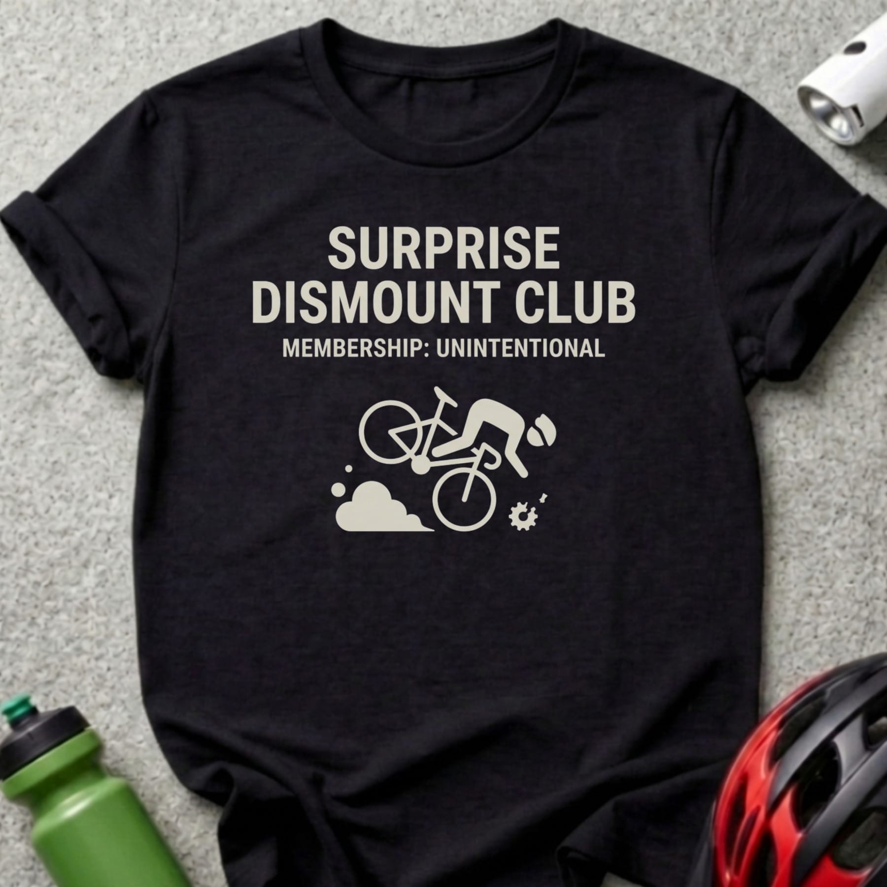 Black t-shirt with "SURPRISE DISMOUNT CLUB MEMBERSHIP: UNINTENTIONAL" text and cycling graphic.