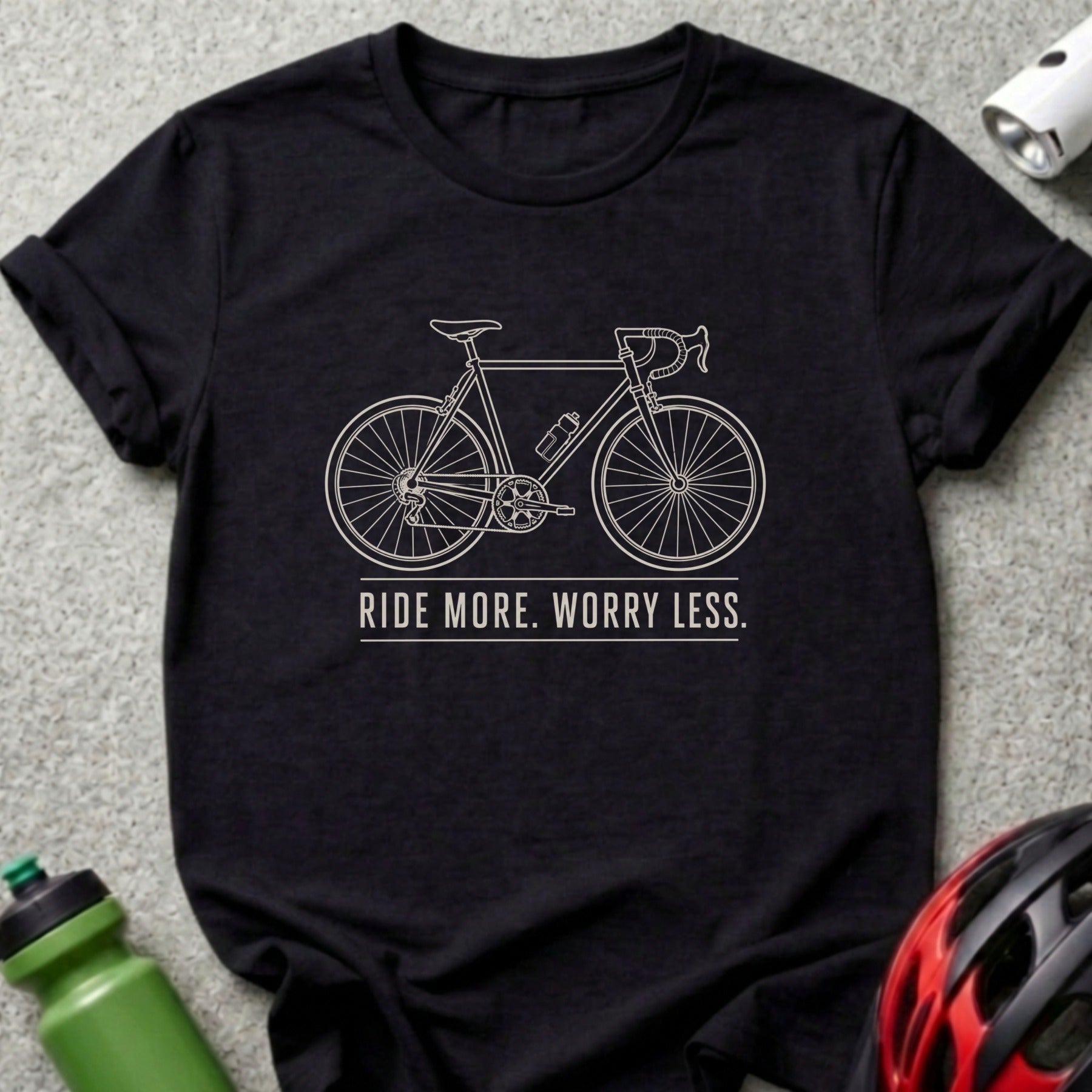 Black t-shirt with line drawing of a bicycle and the text "RIDE MORE. WORRY LESS."