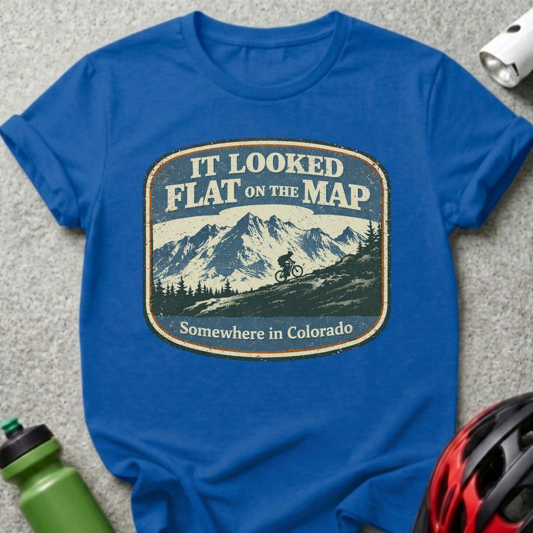 Blue t-shirt with distressed "It Looked Flat on the Map Somewhere in Colorado" graphic.