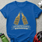 Blue t-shirt with two beer bottles clinking, featuring bicycle silhouettes and "ANTIDEPRESSANTS BEST SHARED WITH A RIDING BUDDY."