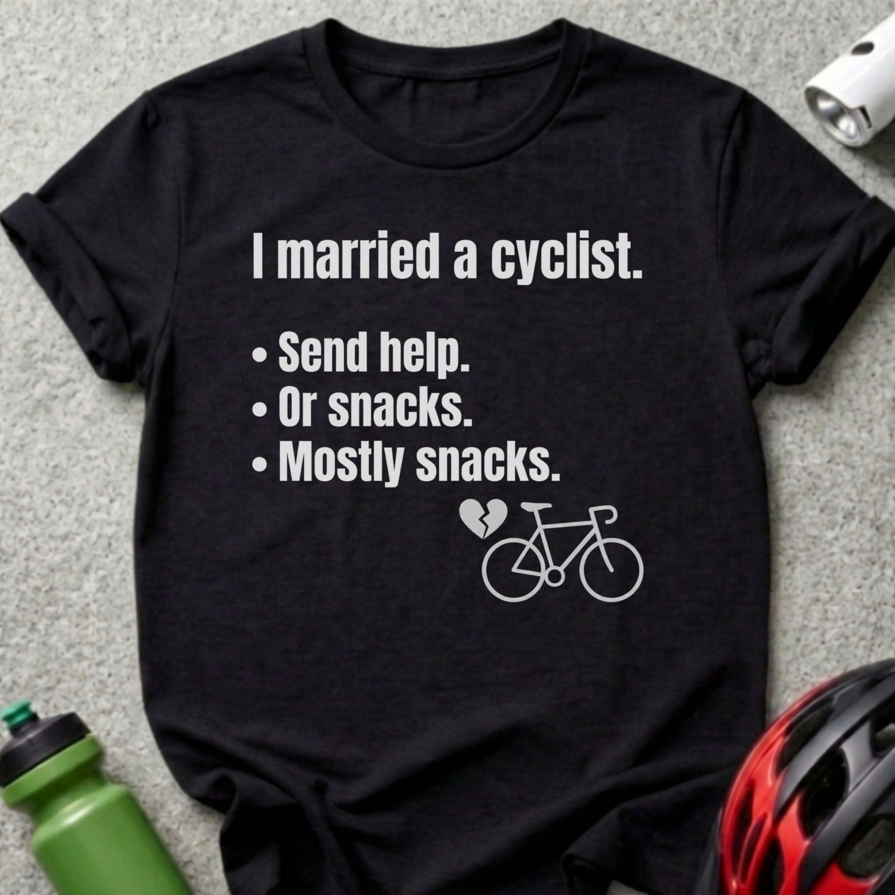 Black t-shirt with text: "I married a cyclist. Send help. Or snacks. Mostly snacks."