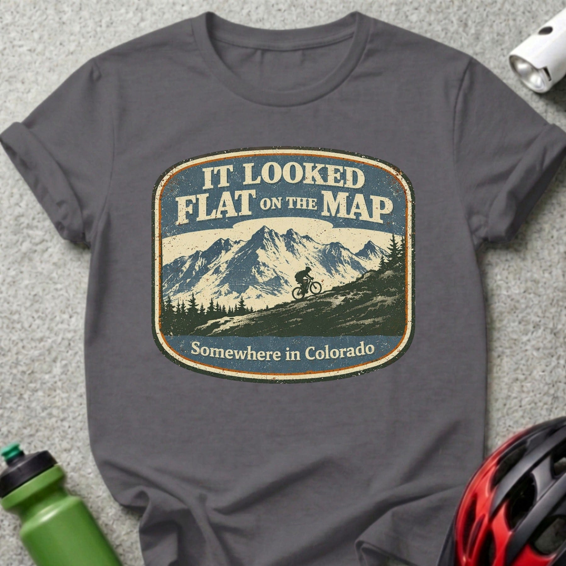 Mountain biker sticker on dark gray t-shirt, "It looked flat on the map"