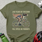 Dog wearing American flag bandana riding a bicycle, text "250 Years of Freedom Full Speed, No Thoughts".