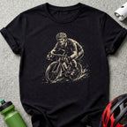T-shirt graphic of a cyclist in motion, with a water bottle and helmet nearby.