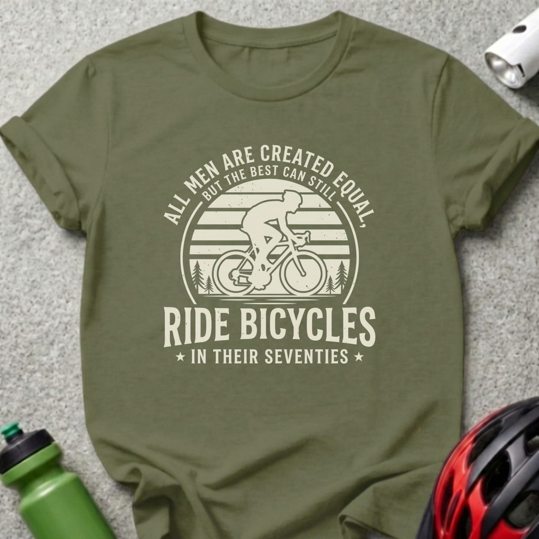 Olive green t-shirt with cyclist graphic and text: "All men are created equal, but the best can still ride bicycles in their seventies."
