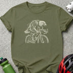 Eagle riding a bicycle, graphic design on olive green t-shirt.