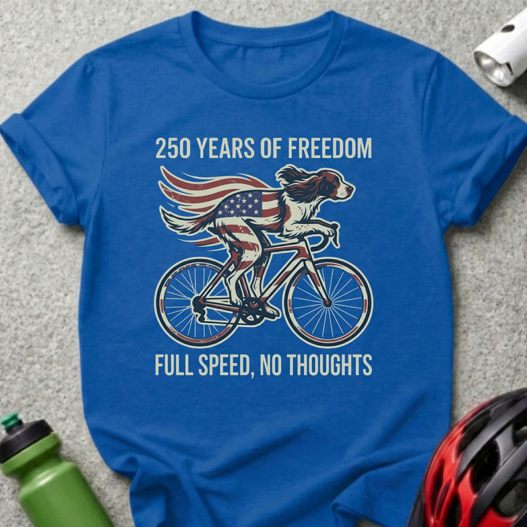 Dog on bicycle with American flag wings, "250 Years of Freedom, Full Speed, No Thoughts".