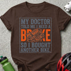 Brown t-shirt with text about needing a brake and buying another bike.