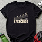 A black short-sleeved t-shirt featuring a graphic of four cyclists ascending musical staff lines with the text CRESCENDO.