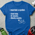 Blue t-shirt with text "I married a cyclist. Send help. Or snacks. Mostly snacks." and bicycle graphic.