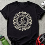Black t-shirt with a circular graphic of a cyclist and text "Retired Not Tired".