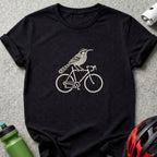 A black crewneck t-shirt featuring a cream-colored graphic of a bird riding a bicycle.