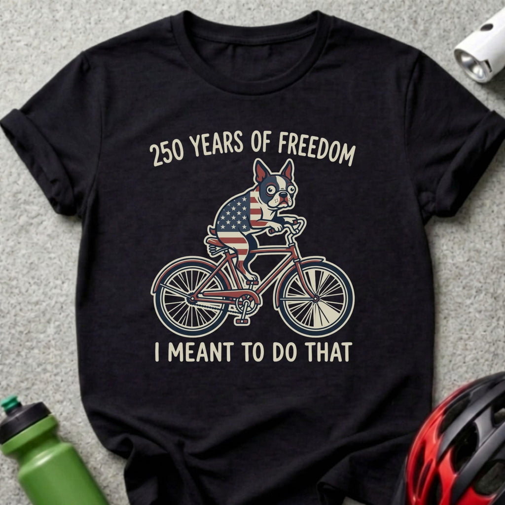 Black t-shirt with a dog on a bicycle and "250 Years of Freedom I Meant To Do That" text.