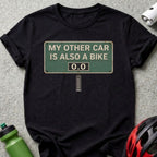 Black t-shirt with "MY OTHER CAR IS ALSO A BIKE" sign graphic.