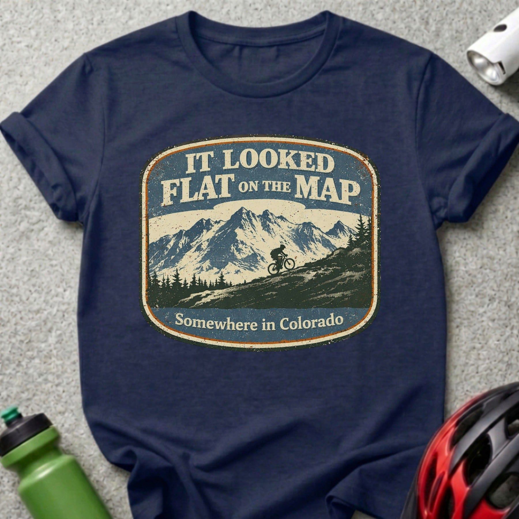 Navy t-shirt with "IT LOOKED FLAT ON THE MAP Somewhere in Colorado" mountain biker graphic.