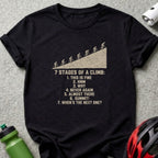 Black t-shirt featuring a graphic and text that list seven stages of a bicycle climb.