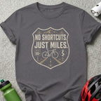 Gray t-shirt with "No Shortcuts. Just Miles." cycling graphic and bicycle.
