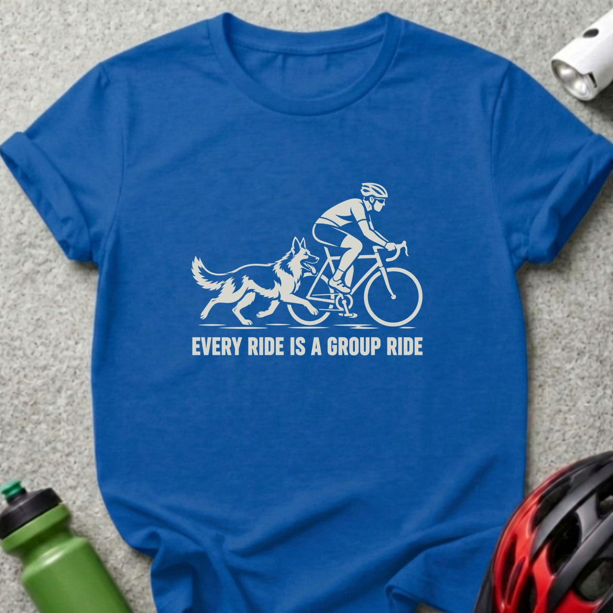 Royal blue t-shirt featuring a white graphic of a cyclist with a dog and the text EVERY RIDE IS A GROUP RIDE.