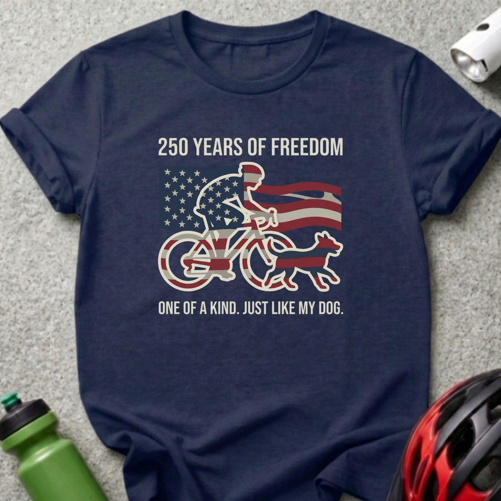 Navy t-shirt with cyclist, dog, American flag, and text "250 YEARS OF FREEDOM ONE OF A KIND. JUST LIKE MY DOG."