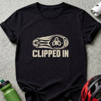 A black short-sleeved t-shirt featuring a graphic of a bicycle cleat sole and the text CLIPPED IN.