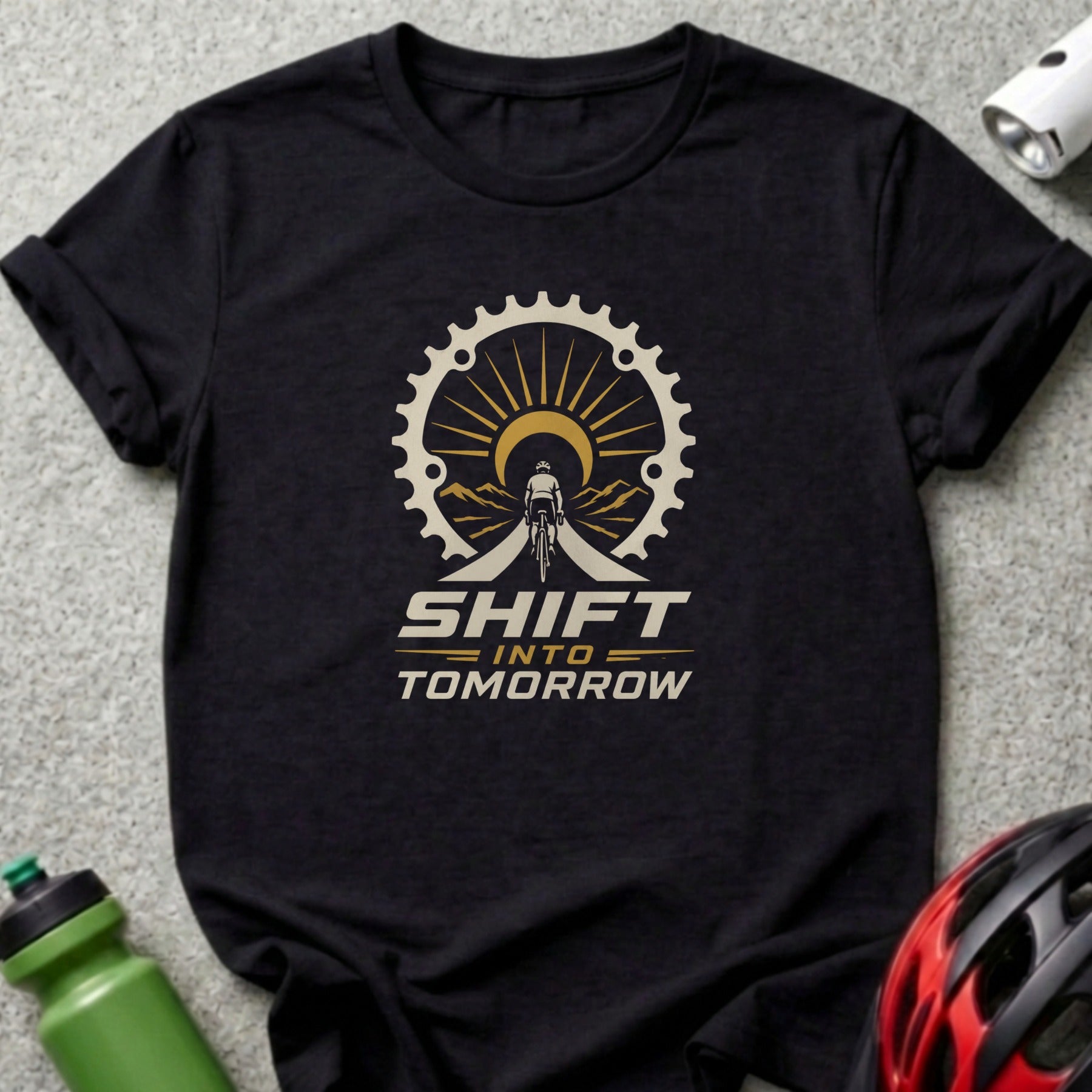 Black t-shirt with bicycle gear, cyclist, mountains, sun, and text "SHIFT INTO TOMORROW".