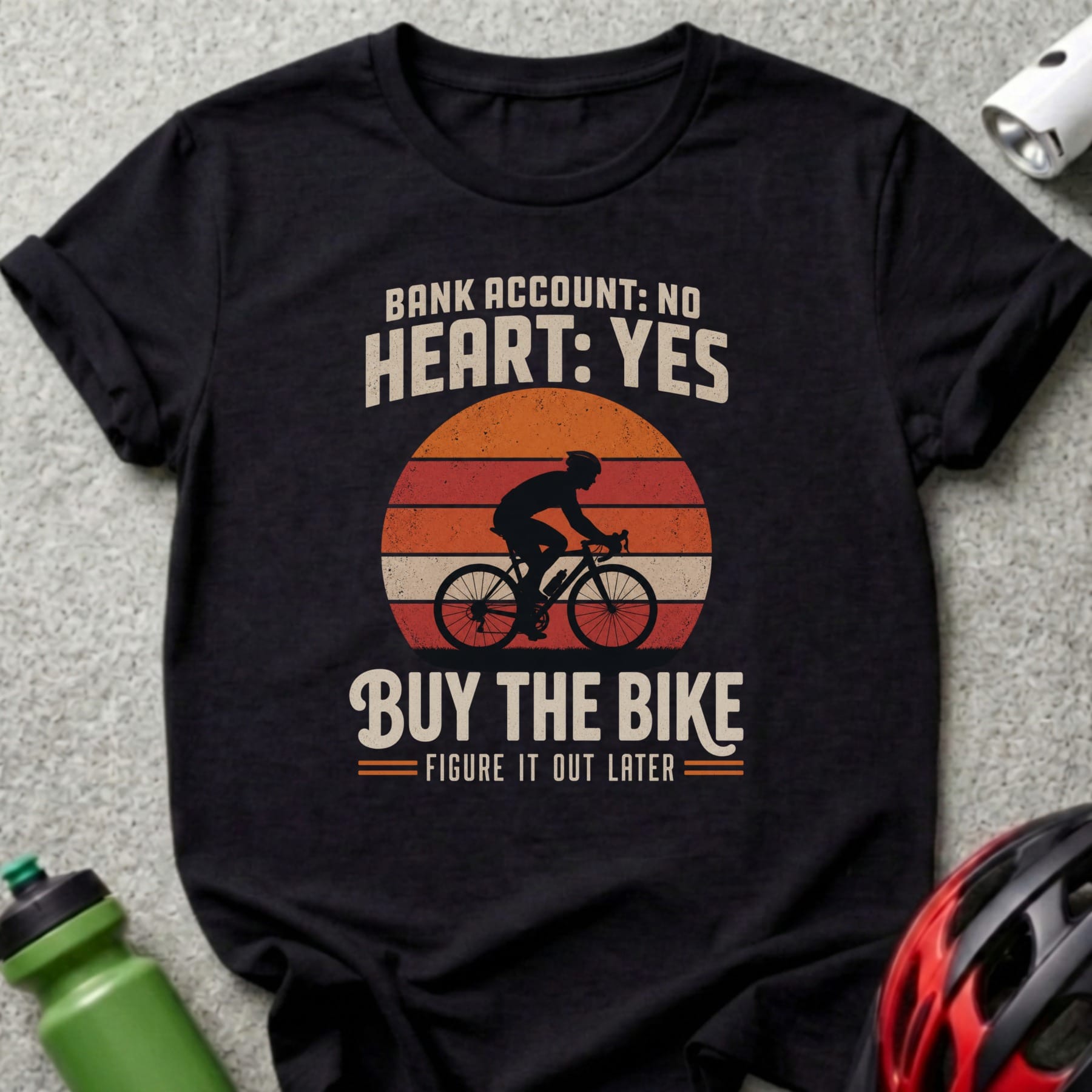 Black t-shirt with a graphic of a cyclist and text "Bank account: No, Heart: Yes, Buy the bike".
