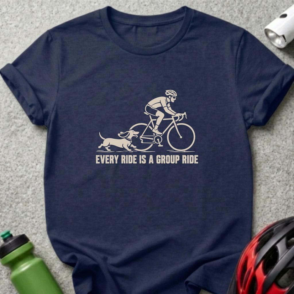 A dark blue t-shirt featuring a graphic of a cyclist and a dachshund running alongside with the text "EVERY RIDE IS A GROUP RIDE".