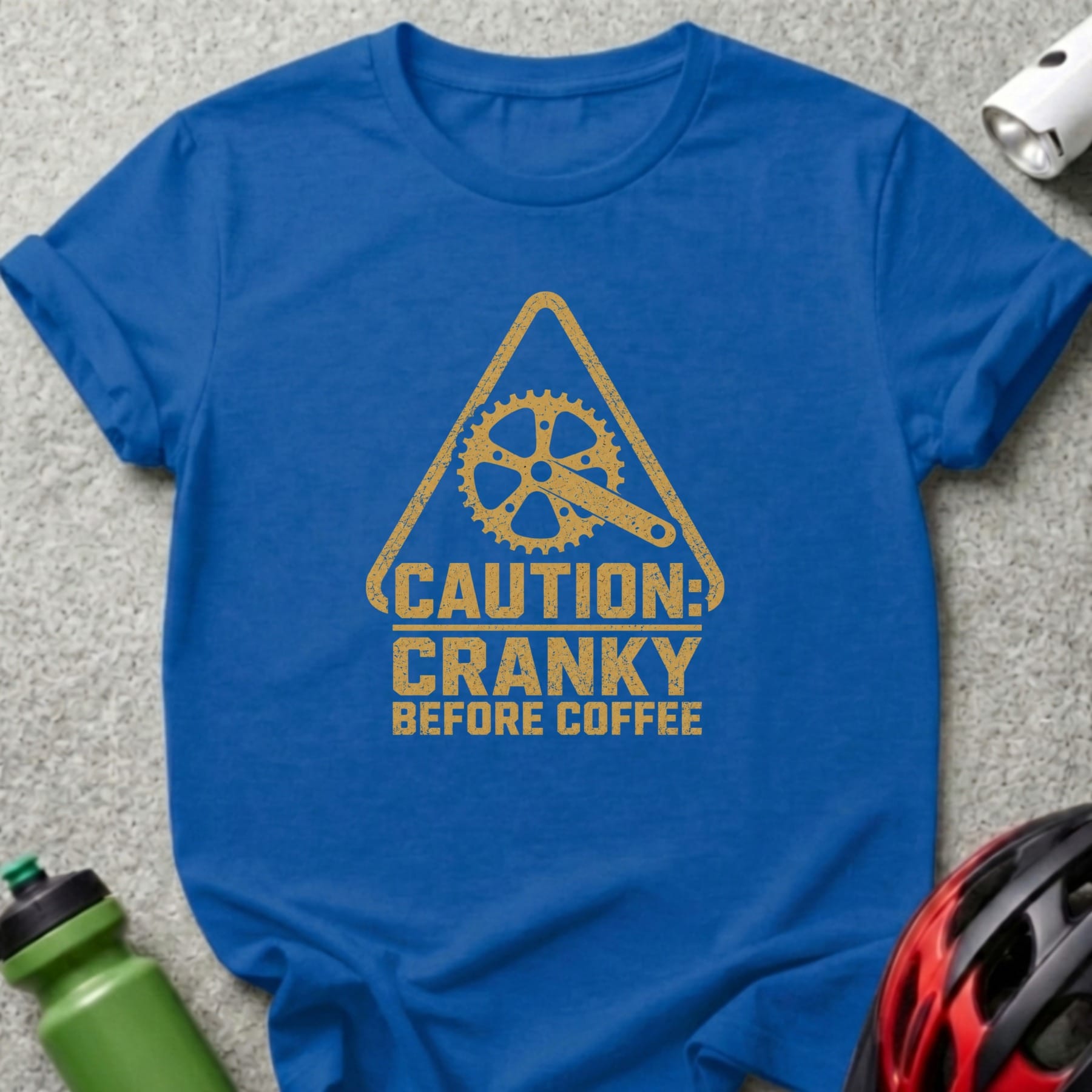 Blue t-shirt with "CAUTION: CRANKY BEFORE COFFEE" text and bicycle gear graphic.