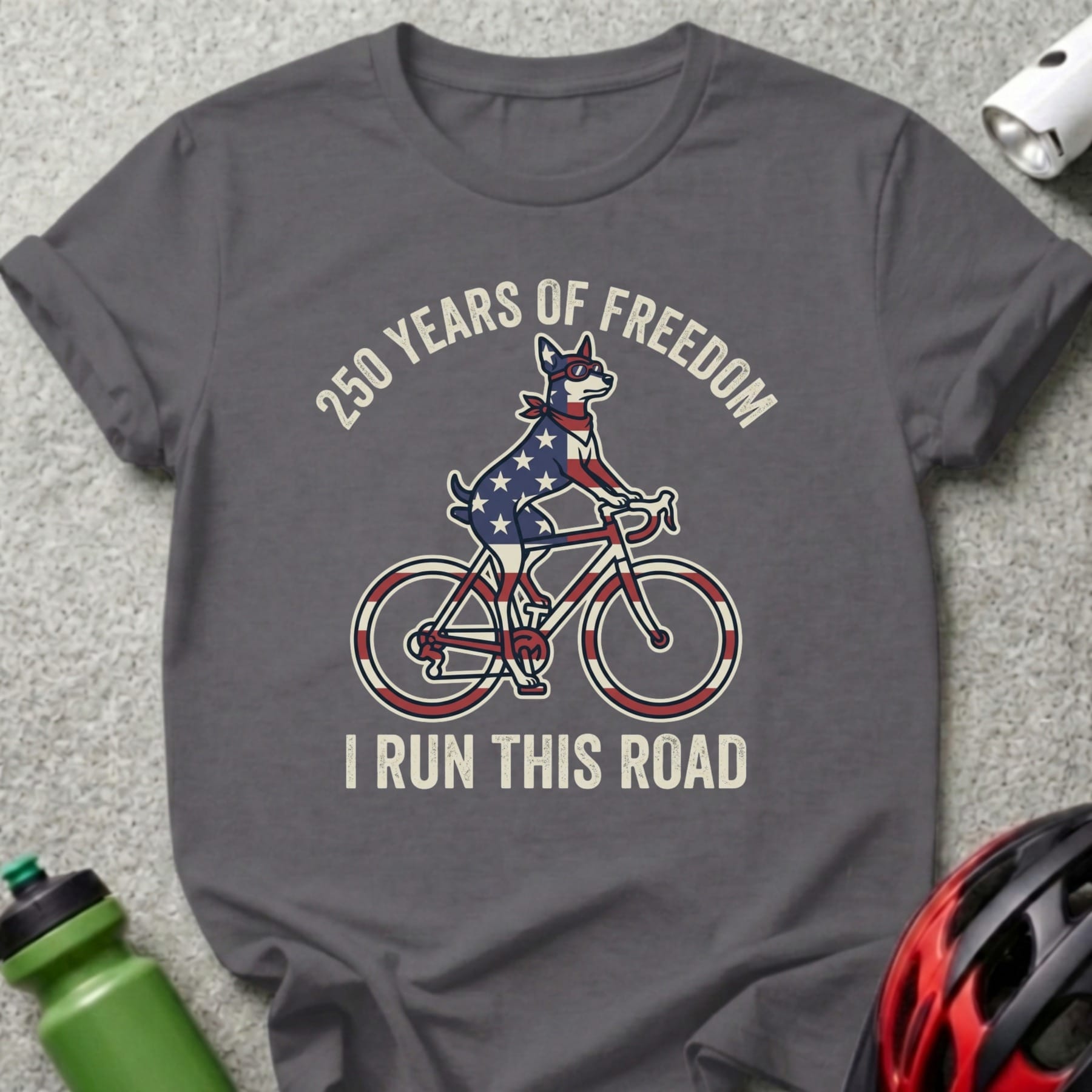 Dog in American flag bandana rides bicycle with text "250 Years of Freedom I Run This Road".