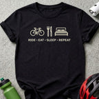 Black t-shirt with bicycle, fork and knife, and bed icons and "RIDE • EAT • SLEEP • REPEAT" text.