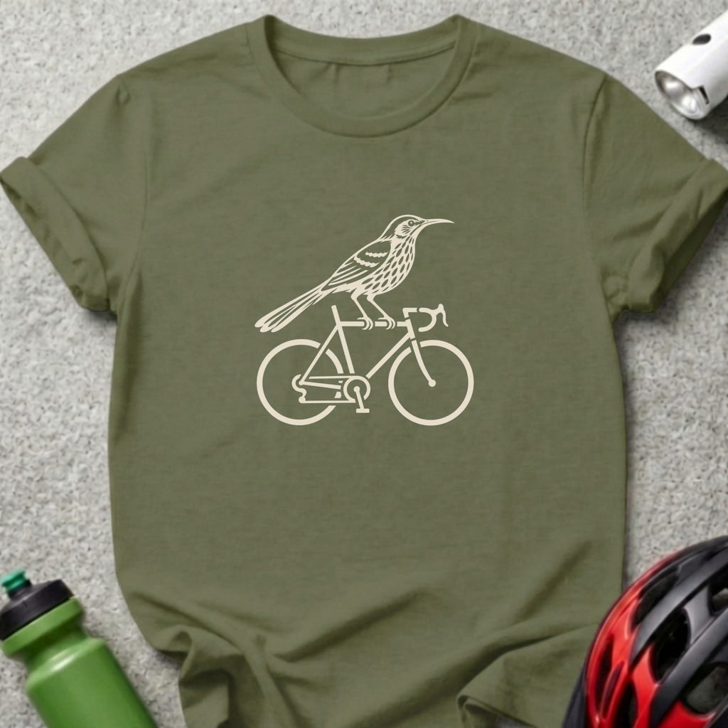 An olive green t-shirt features a cream graphic of a bird perched on a bicycle frame.