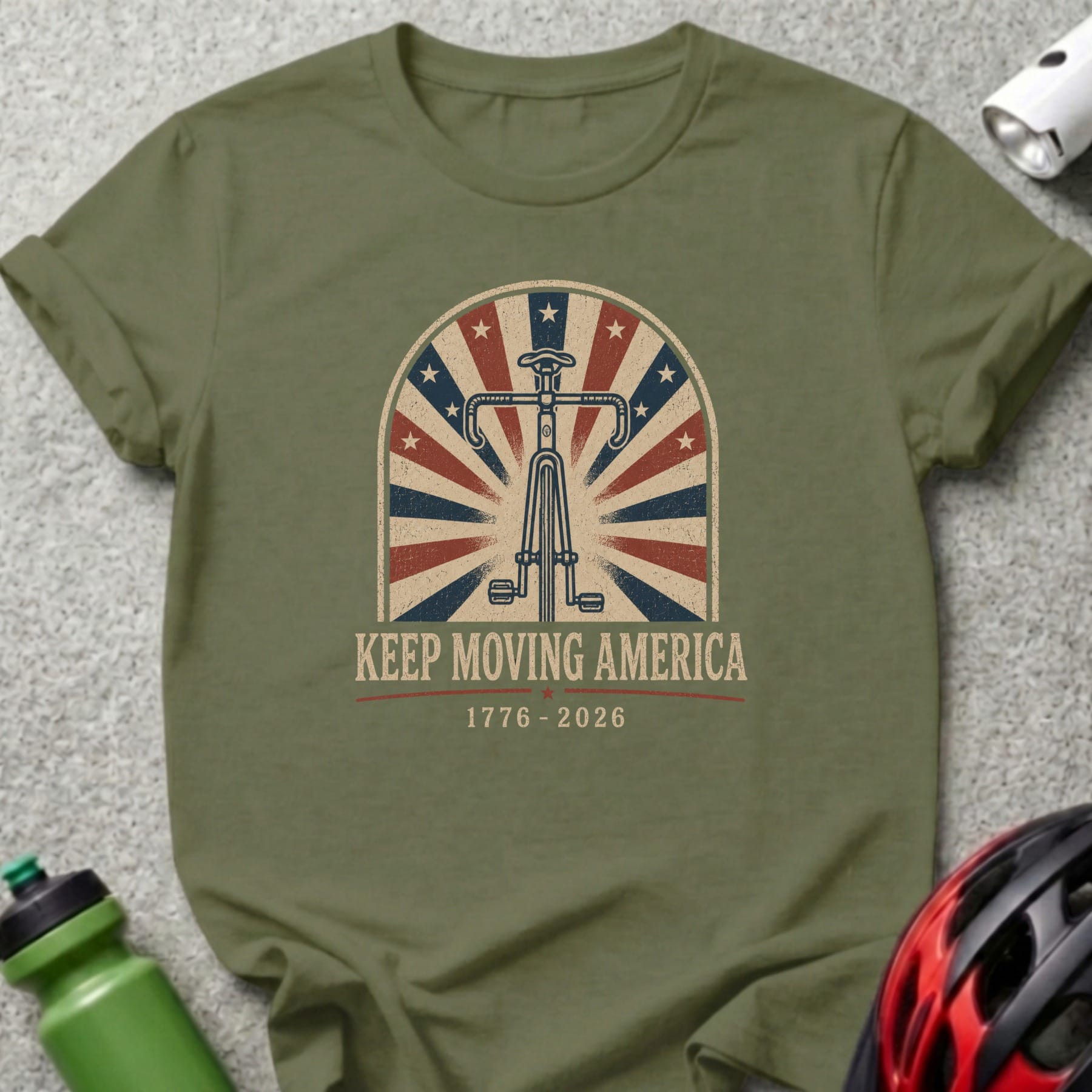 Olive green t-shirt with patriotic bicycle and "Keep Moving America" text.