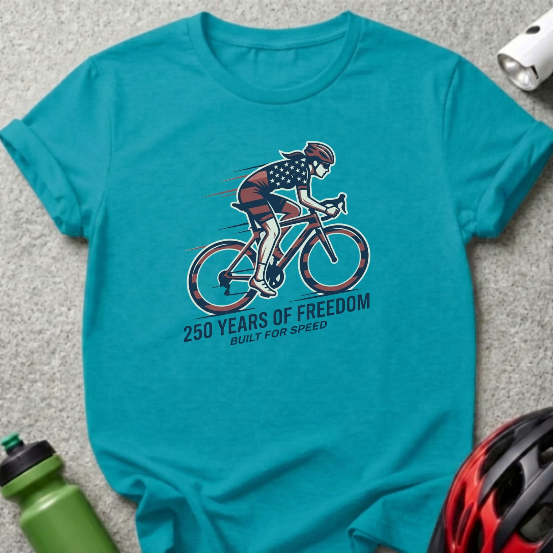 Teal t-shirt with cyclist graphic and text "250 YEARS OF FREEDOM BUILT FOR SPEED".
