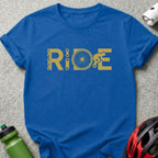 Blue t-shirt with gold "RIDE" graphic featuring a bicycle chain, wheel, and cyclist.
