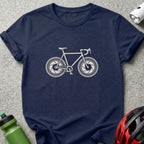 A dark blue crewneck t-shirt featuring a beige graphic of a bicycle with camera aperture wheels.