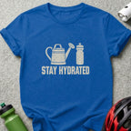 A blue t-shirt printed with a watering can, a water bottle, and the text stay hydrated.