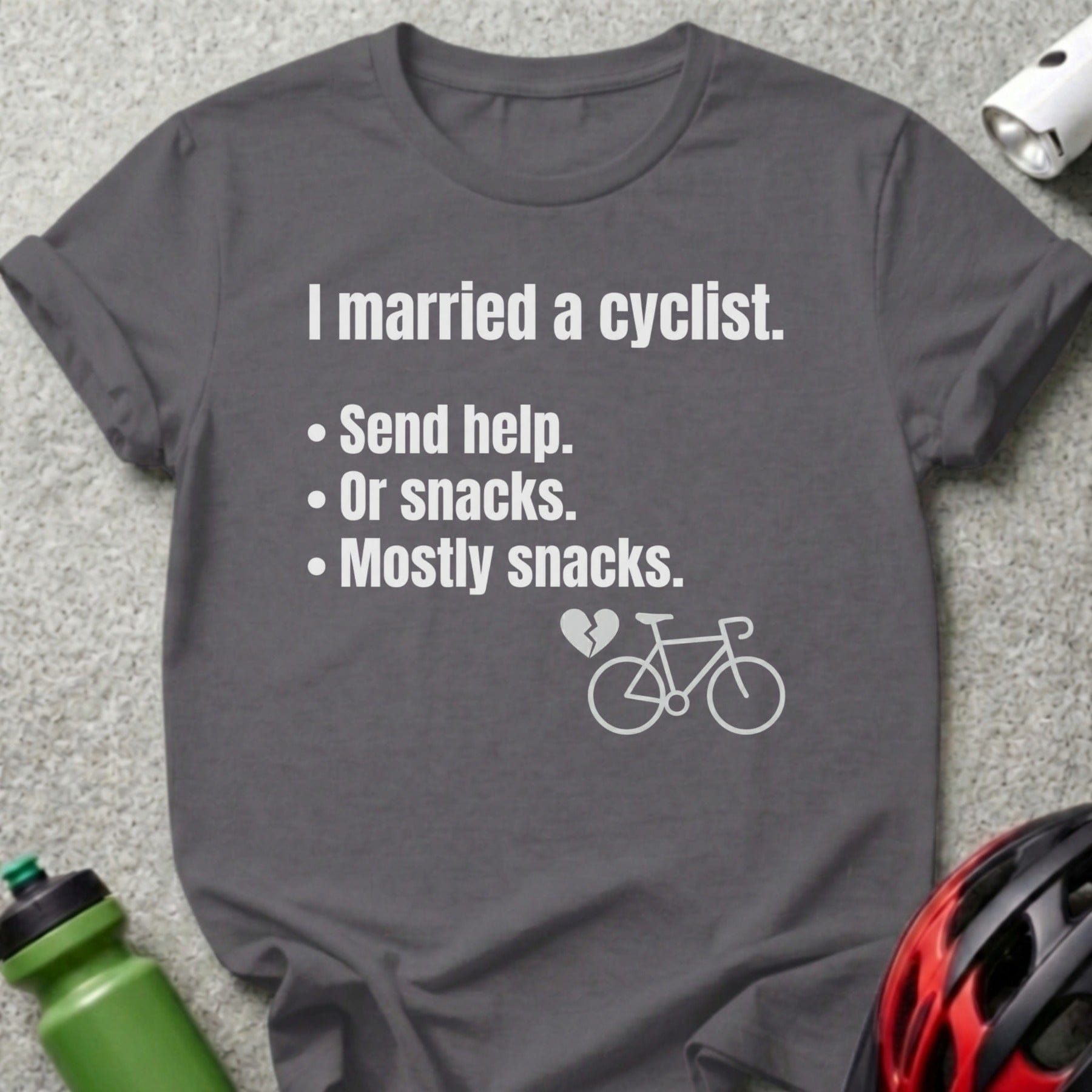 Gray t-shirt with text "I married a cyclist. Send help. Or snacks. Mostly snacks." and a bicycle icon.