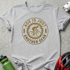 T-shirt with graphic "Age is just another gear" and bicycle wheel design.