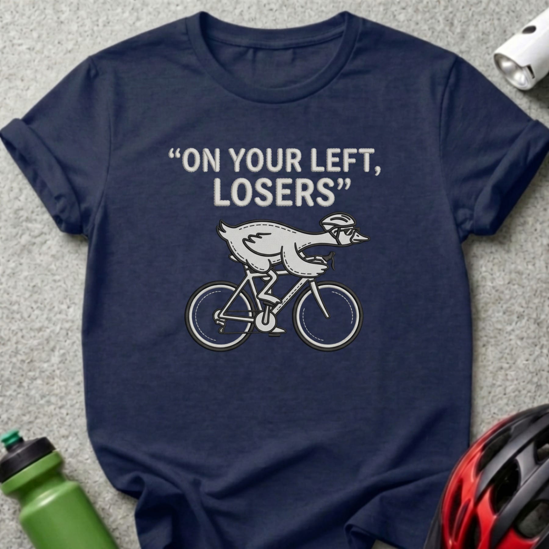 T-shirt with a goose in a helmet riding a bicycle, text "On Your Left, Losers".
