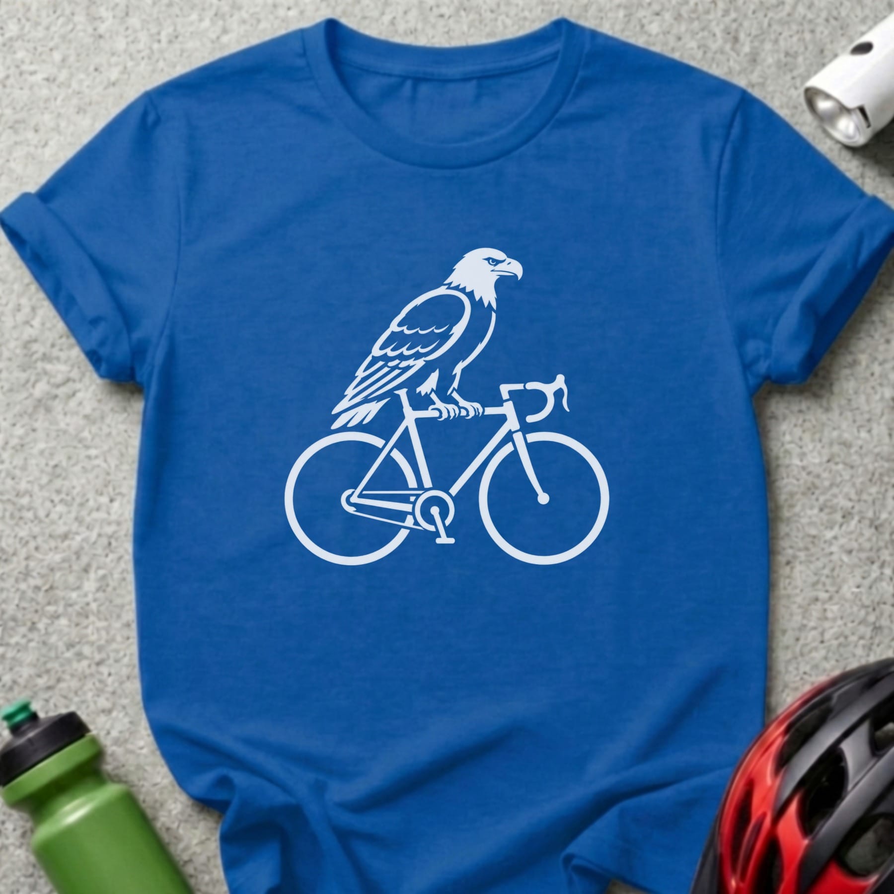 White eagle silhouette riding a bicycle on a blue t-shirt.