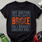 T-shirt with "My Doctor Told Me I Need a Brake So I Bought Another Bike" text and bike brake graphic.