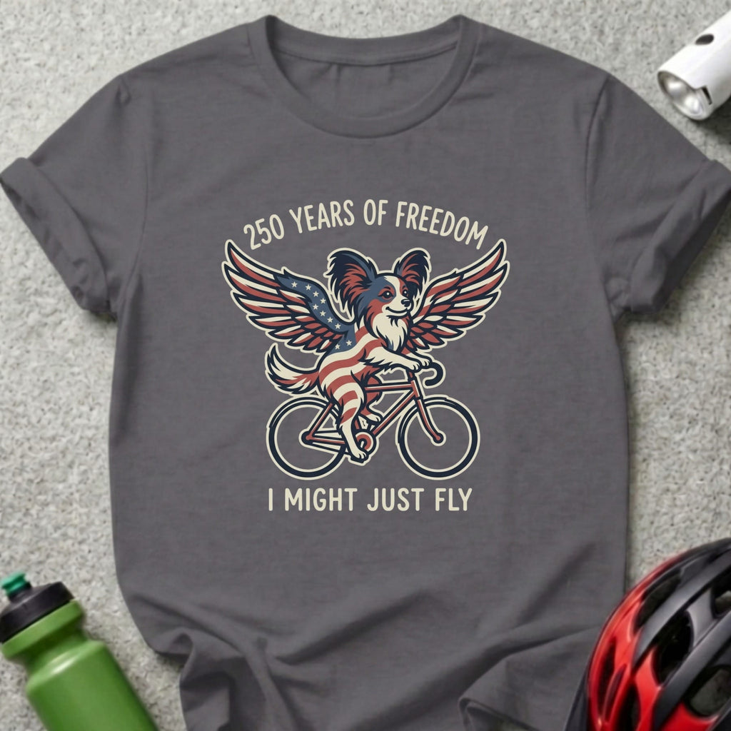 Dog with American flag wings rides a bicycle with text "250 Years of Freedom I Might Just Fly".