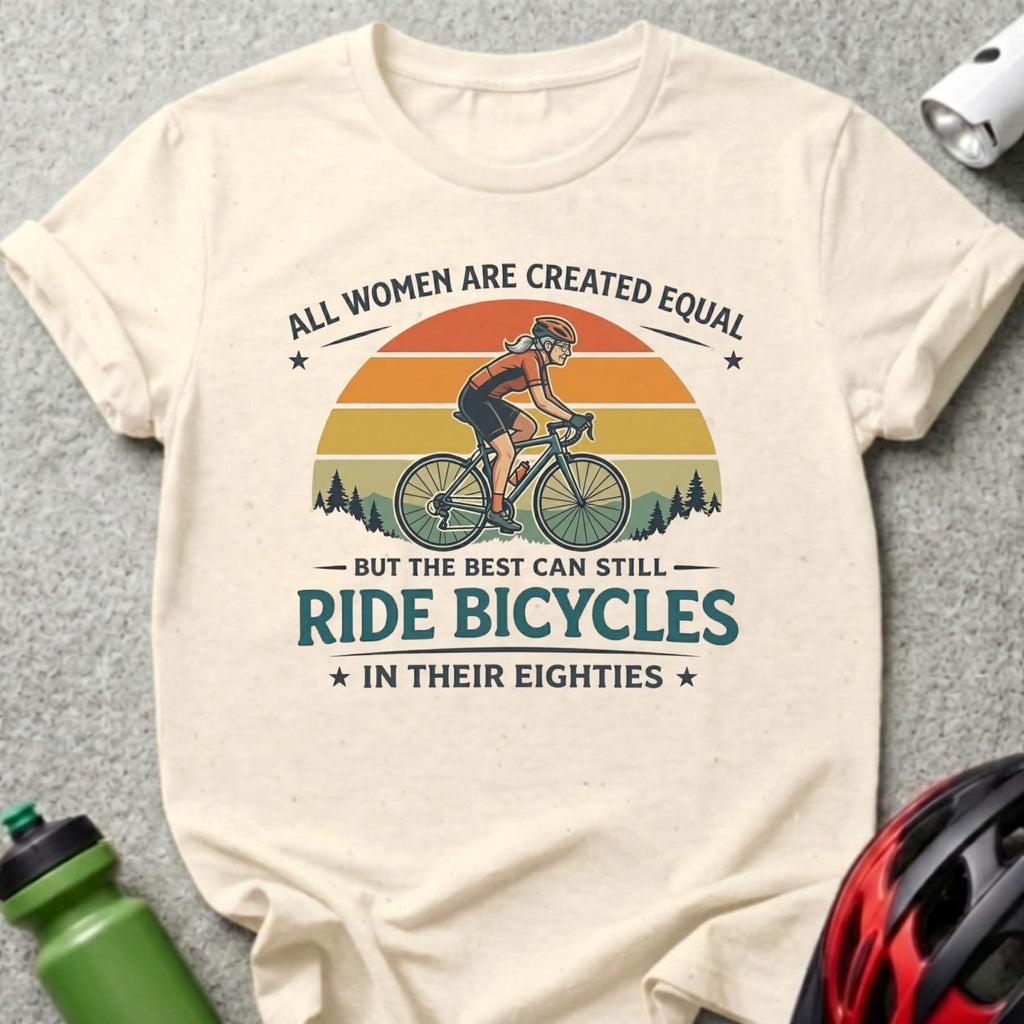 Cream t-shirt with vintage cycling graphic and text "All women are created equal, but the best can still ride bicycles in their eighties."