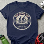 Navy t-shirt with circular graphic of cyclists on a tandem bike, "Better Together Ride as One."