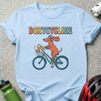 Light blue t-shirt with cartoon dog wearing headphones biking with pills in basket.