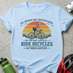 Light blue t-shirt with text and graphic of a woman riding a bicycle.