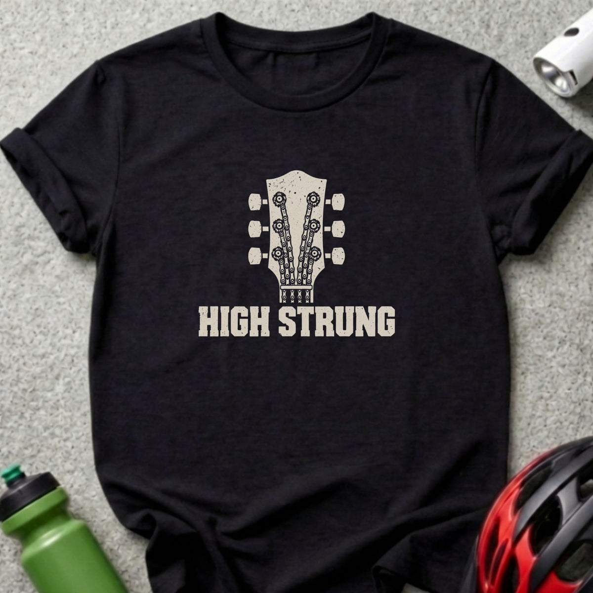 A black t-shirt featuring a graphic of a guitar headstock made of bicycle chains and the text "HIGH STRUNG".