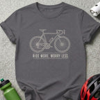Dark grey t-shirt with a minimalist line drawing of a bicycle and the text "RIDE MORE. WORRY LESS."